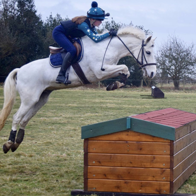 Horse and rider jumping cross country fence